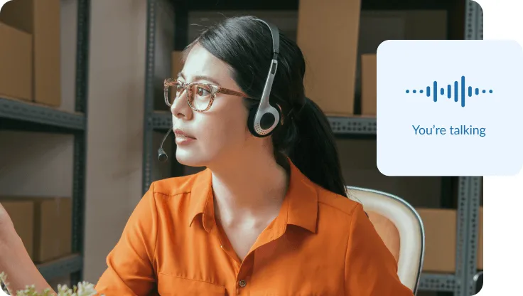 A female admin officer wearing a headset in a warehouse