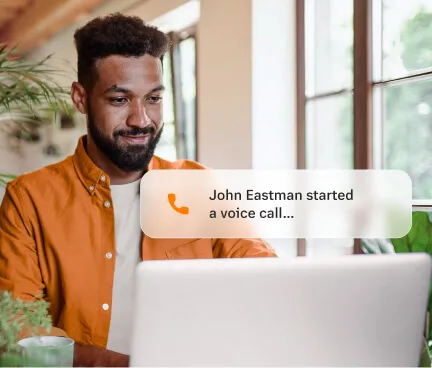 A male call center agent joining a voice call through his laptop