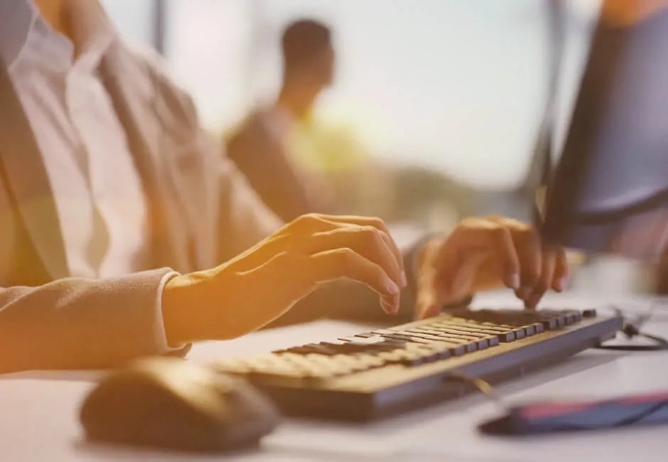 Video still of an office employee typing on a keyboard